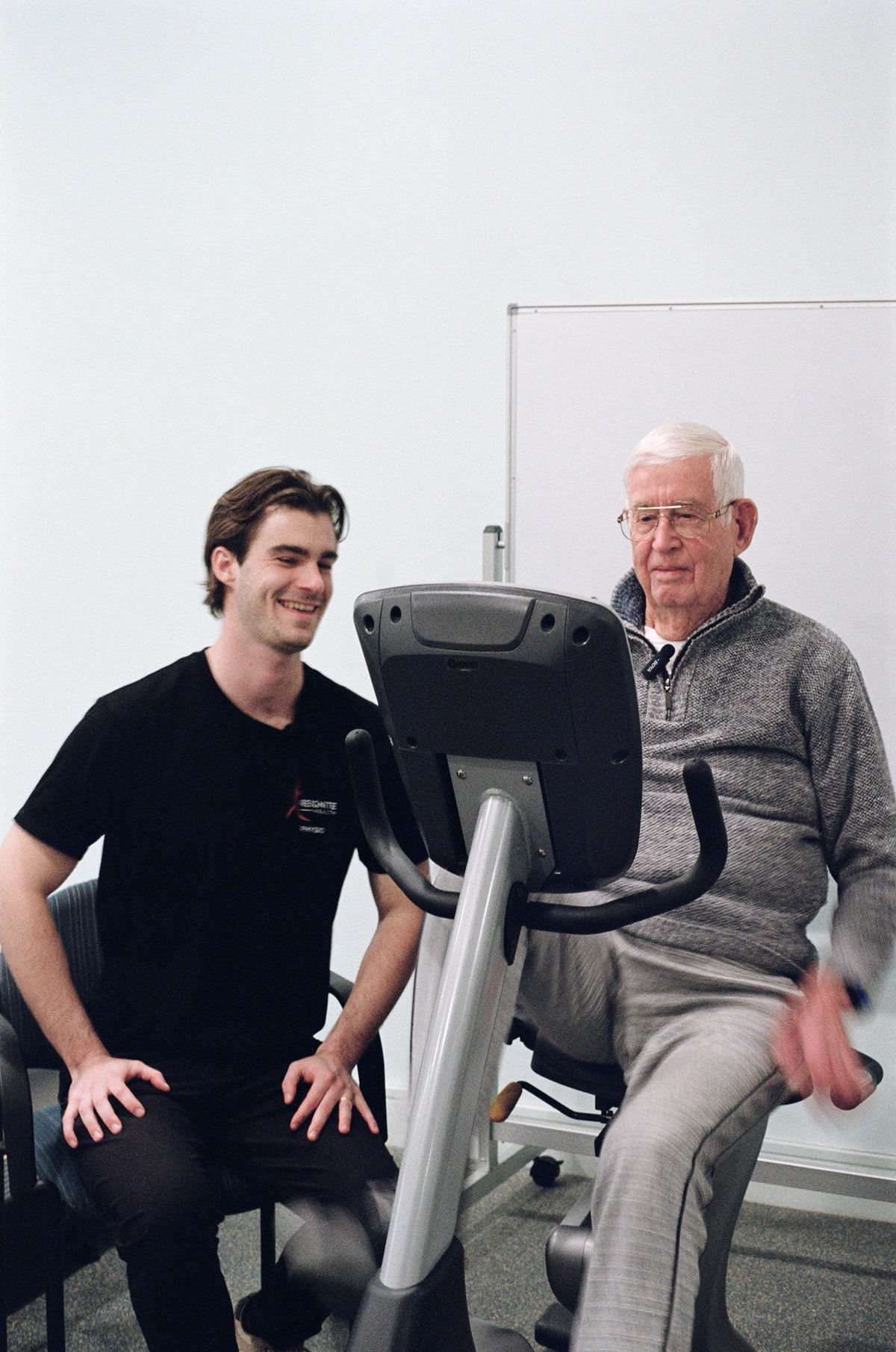 Reignite Health physiotherapist providing one-on-one exercise bike supervision for elderly resident