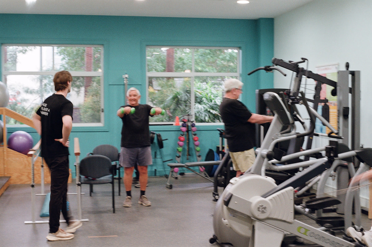 Retirement village residents training with dumbbells and gym equipment supervised by Reignite Health team