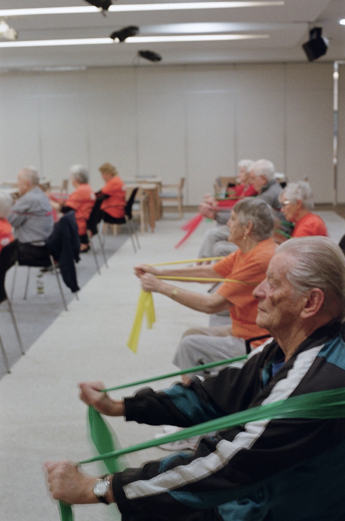 Elderly residents performing seated resistance band exercises during falls prevention class